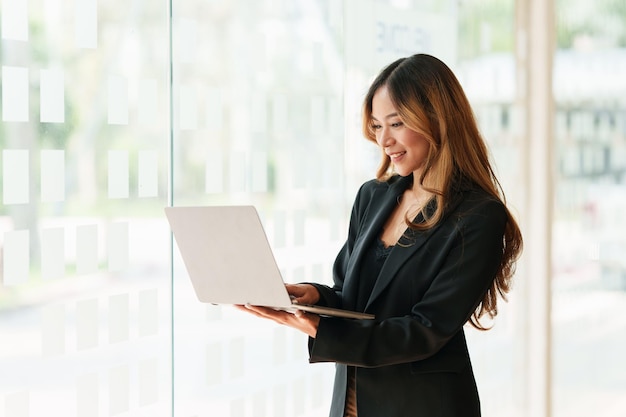 La donna d'affari asiatica moderna ha fiducia nel lavorare con il team finanziario tramite videoconferenza in ufficio Concetto di contabilità