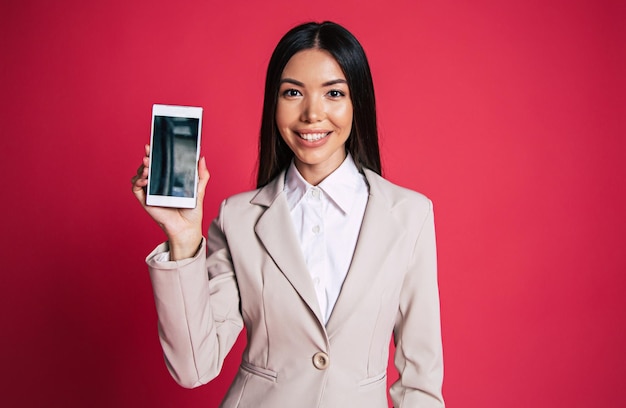 La donna d'affari asiatica sicura di successo sta parlando al telefono con il cliente