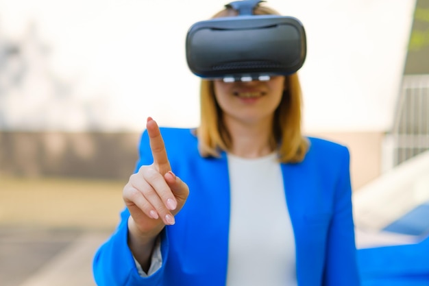 La donna d'affari controlla l'interfaccia virtuale premendo i pulsanti con il dito negli occhiali vr in t