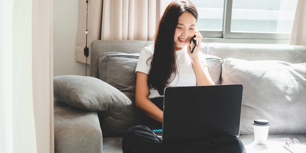 La donna d'affari lavora con il computer portatile da casa, la donna che lavora con il business e la tecnologia della comunicazione online, scrivania sul posto di lavoro con notebook al coperto isolato in una casa