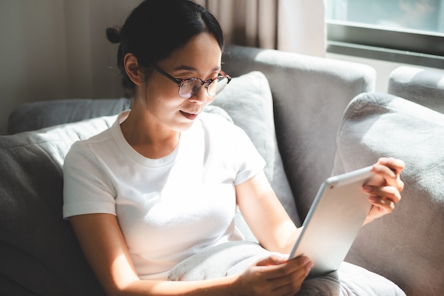 La donna d'affari lavora con il computer portatile da casa, la donna che lavora con il business e la tecnologia della comunicazione online, scrivania sul posto di lavoro con notebook al coperto isolato in una casa