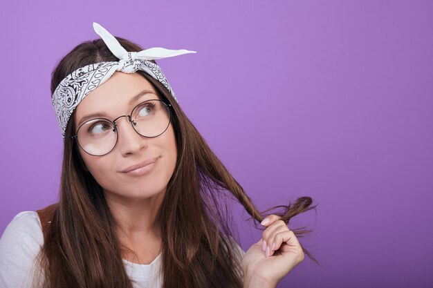 La donna dai capelli castani divertente distoglie lo sguardo, primo piano.