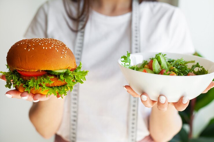 Foto la donna decide di mangiare hamburger o insalata fresca in cucina