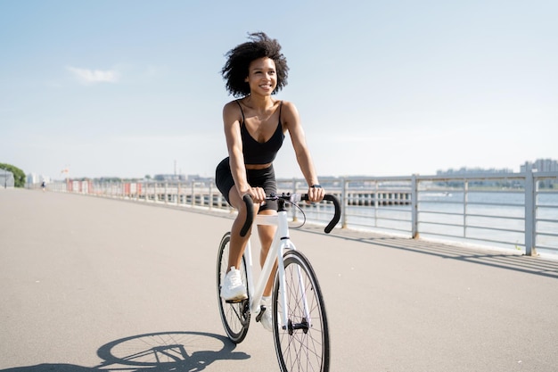 La donna del ciclista guida un trasporto ecologico di allenamento per il fitness in bici da strada