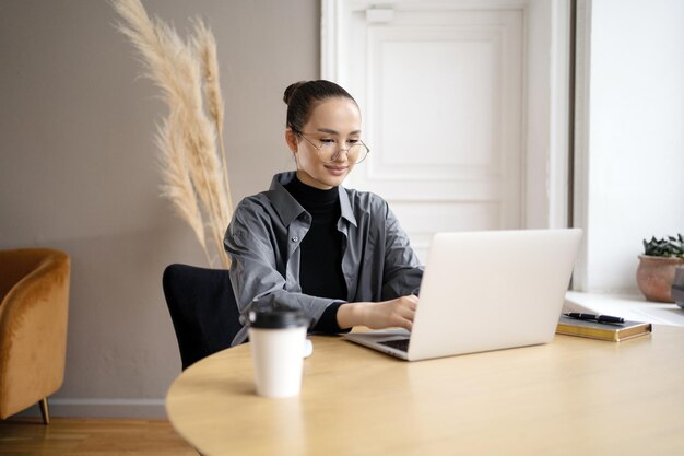 La donna del finanziere utilizza il computer portatile in ufficio per la finanza e il bilancio in azienda