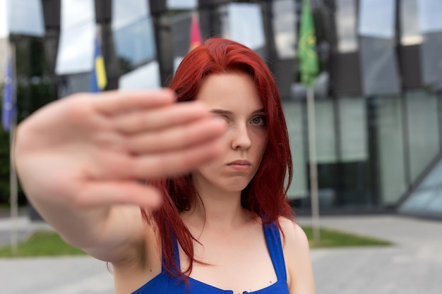 La donna del ritratto con i capelli rossi mostra la foto della mano di arresto sulla strada