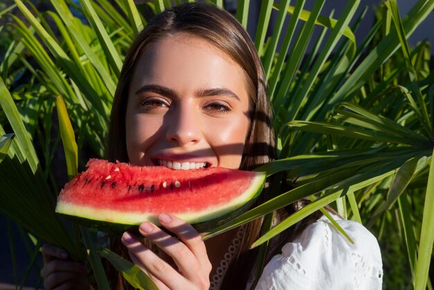 La donna del ritratto di estate sta tenendo una fetta di cha positivo del concetto di viaggio di vacanza tropicale dell'anguria