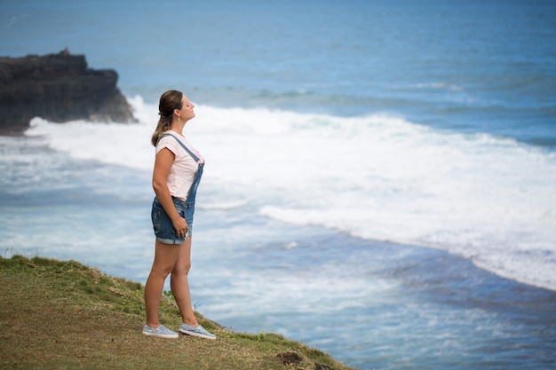 La donna del viaggiatore di libertà in cima alla montagna e gode della bella vista sul mare. Mauritius