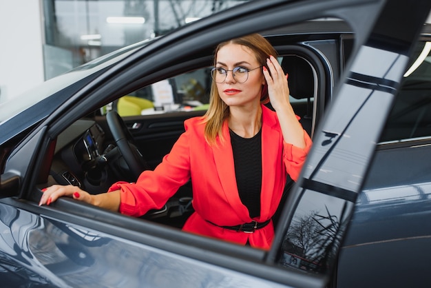 La donna di affari acquista un'auto presso una concessionaria di automobili