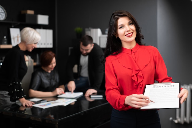 La donna di affari con la penna e il contratto sugli impiegati discutono del progetto