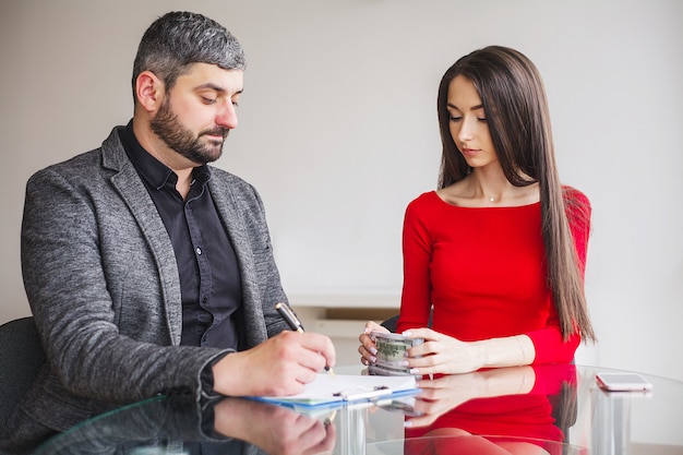 La donna di affari dà soldi agli uomini.