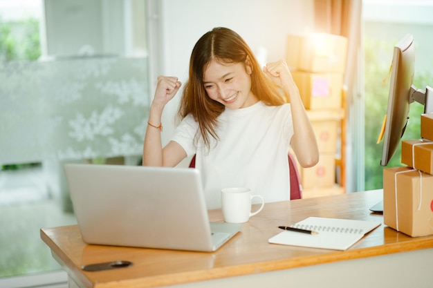 La donna di affari del proprietario dell'adolescente delle belle donne lavora a casa per lo shopping online, scrivendo l'ordine e preparando il prodotto del pacchetto con il concetto di stile di vita dell'imprenditore dell'attrezzatura per ufficio