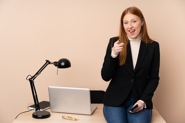 La donna di affari in un ufficio indica il dito voi