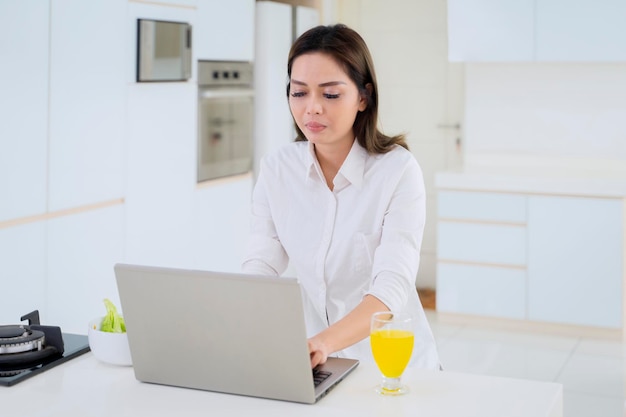 La donna di affari lavora con il computer portatile mentre mangia insalata