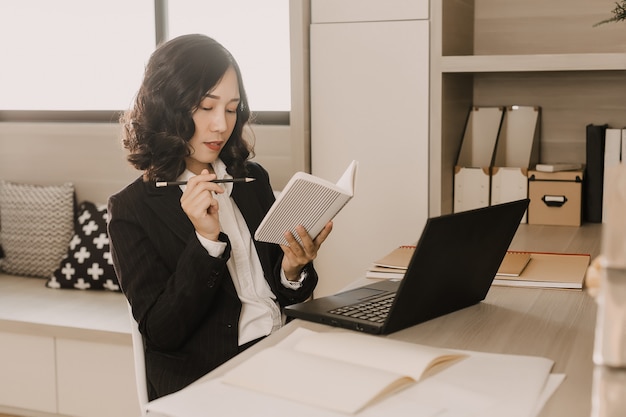 La donna di affari pensa di scrivere qualcosa sul taccuino.