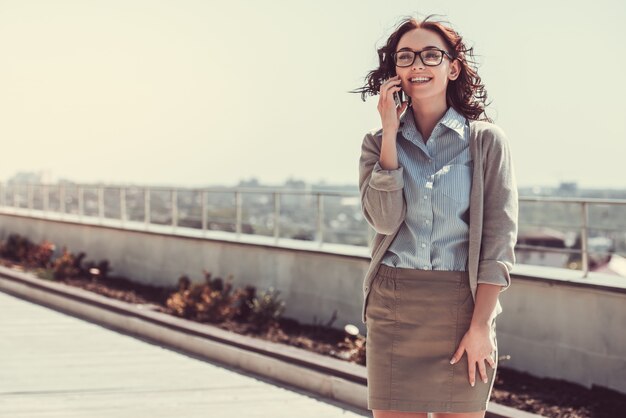 La donna di affari sta parlando sul telefono cellulare.