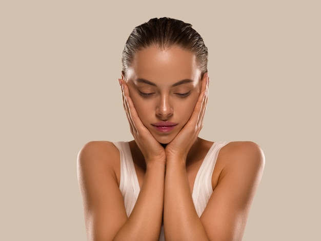 La donna di bellezza con le mani naturali sane compone il fondo di colore di concetto di pelle fresca pulita marrone