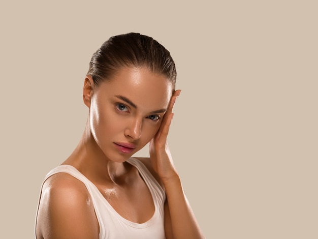 La donna di bellezza con le mani naturali sane compone il fondo di colore di concetto di pelle fresca pulita marrone