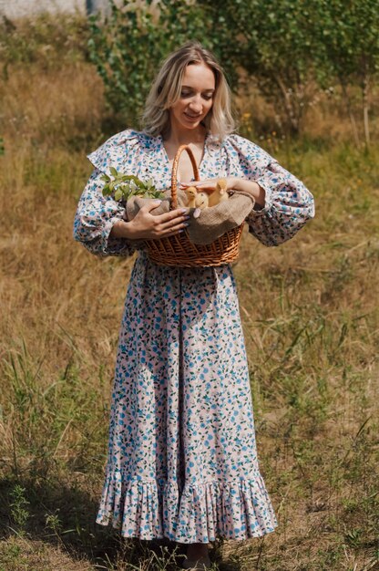 La donna di campagna porta gli anatroccoli gialli in un cesto