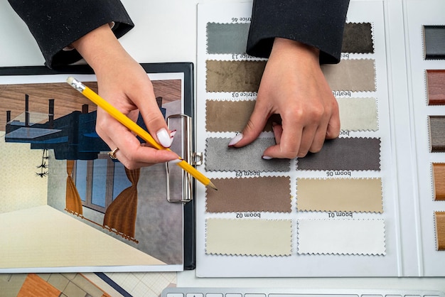 La donna di design progetta l'interno della casa illustra e sceglie i colori perfetti per la nuova casa con campioni di materiali in legno su idee di design immobiliare tavolo