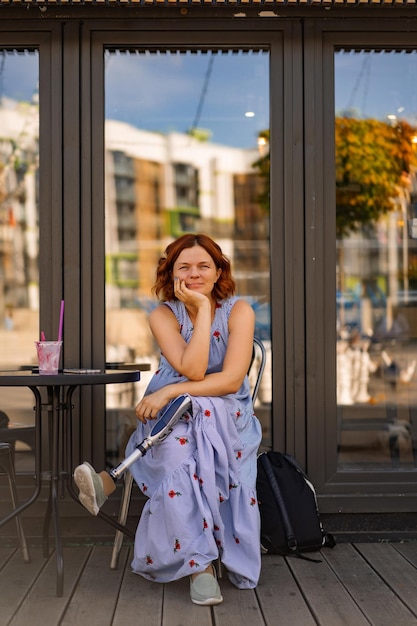 La donna disabile positiva in un caffè sorride, ride, si gode la vita.