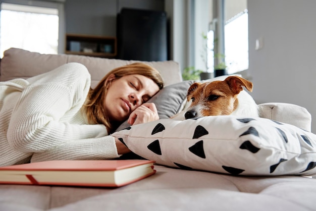 La donna dorme con il cane sul divano