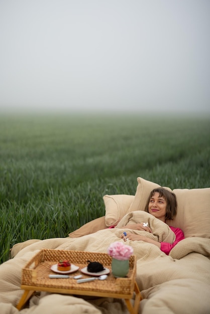 La donna dorme sul letto su un campo verde