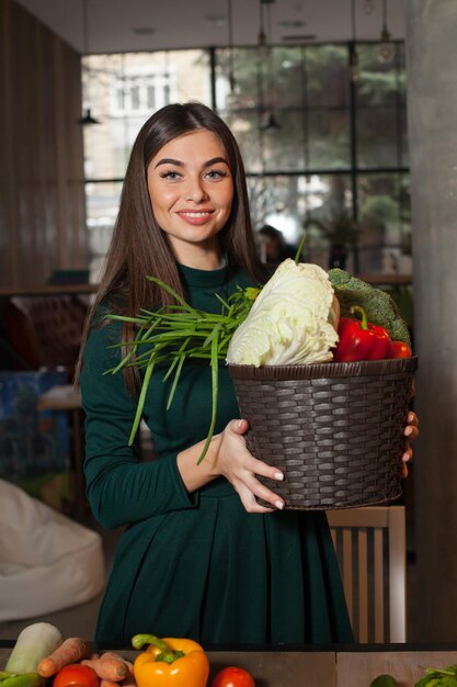 La donna è in piedi con un cesto di verdure