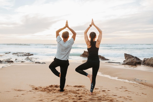 La donna e l'uomo europei maturi in abbigliamento sportivo praticano lo yoga meditano si divertono ad allenarsi insieme al mattino