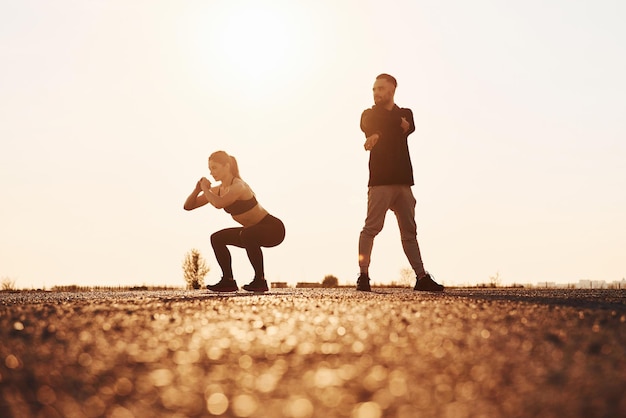 La donna e l'uomo hanno una giornata di fitness sulla strada la sera insieme