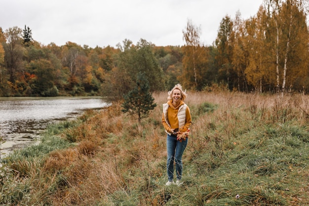 La donna è nel parco d'autunno Vista panoramica dell'atmosfera autunnale del fiume