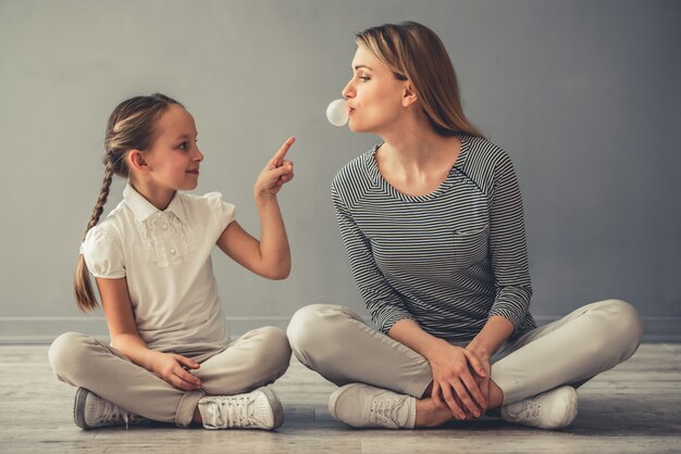 La donna e sua figlia carina stanno giocando con la gomma da masticare.