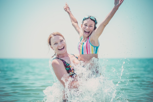 La donna e sua figlia si divertono in mare.