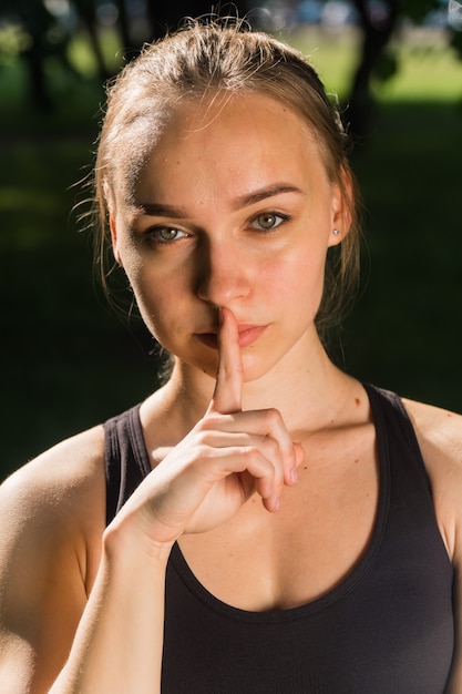 La donna elegante tiene la sua mano sul labbro. Il concetto di segno di silenzio. Avvertimento di un ingegnere in un cantiere