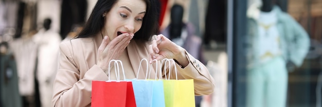 La donna entusiasta esamina le borse della spesa nel centro commerciale