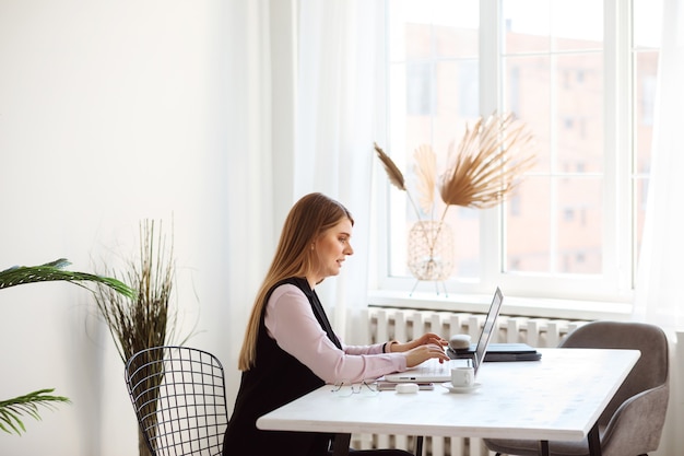 La donna europea sta lavorando sul suo laptop dall'ufficio o da casa