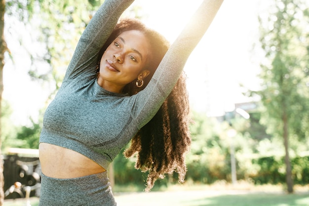 La donna fa esercizi di stretching in palestra all'aperto in una giornata di sole