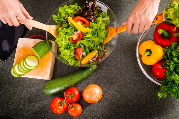 La donna fa un&#39;insalata di verdure fresche