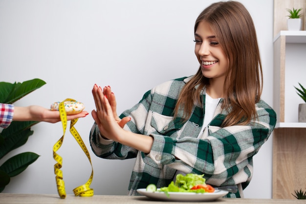 La donna fa una scelta tra cibo sano e nocivo