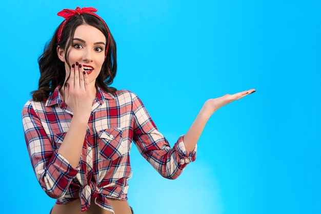 La donna felice che gesticola sullo sfondo blu