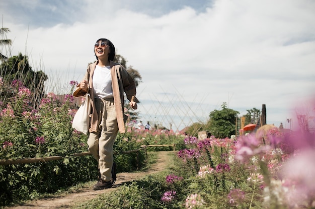 La donna felice corre e sorride alla campagna