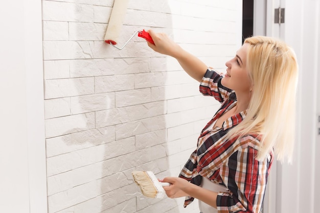 la donna felice fa le riparazioni nella stanza a casa