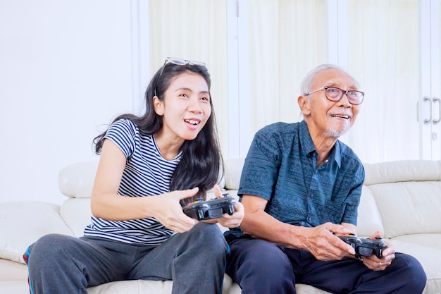 La donna felice gioca ai videogiochi con suo padre