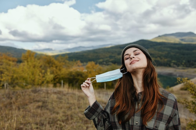 La donna felice si è tolta la maschera medica dal viso nella natura nella foresta