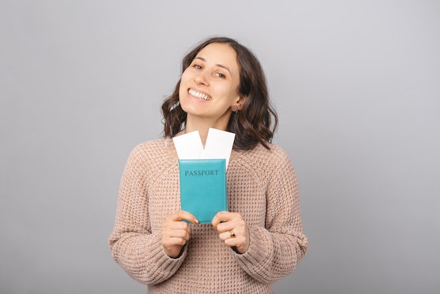 La donna felicissima tiene il passaporto con due biglietti con entrambe le mani