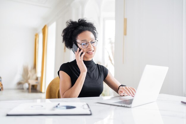 La donna freelance lavora con i documenti online nel computer portatile sul posto di lavoro dell'ufficio sulla finanza del tavolo nell'azienda