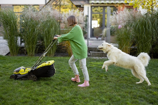 La donna gioca con il suo cane in cortile mentre fa giardinaggio