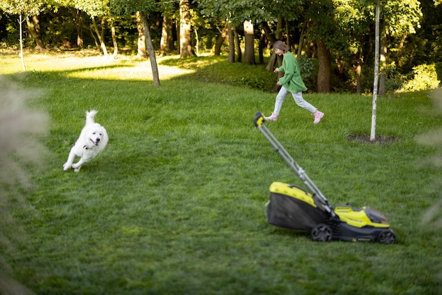 La donna gioca con il suo cane in cortile mentre fa giardinaggio