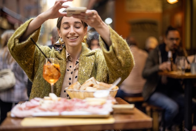 La donna gode della gastronomia italiana al ristorante all'aperto