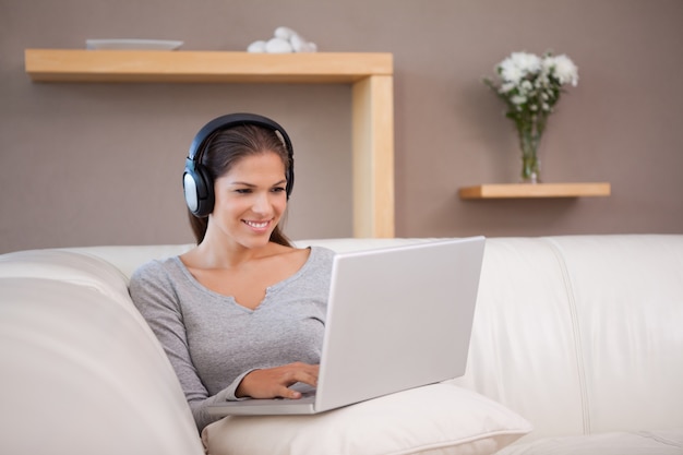 La donna gode di ascoltare la musica sul suo computer portatile